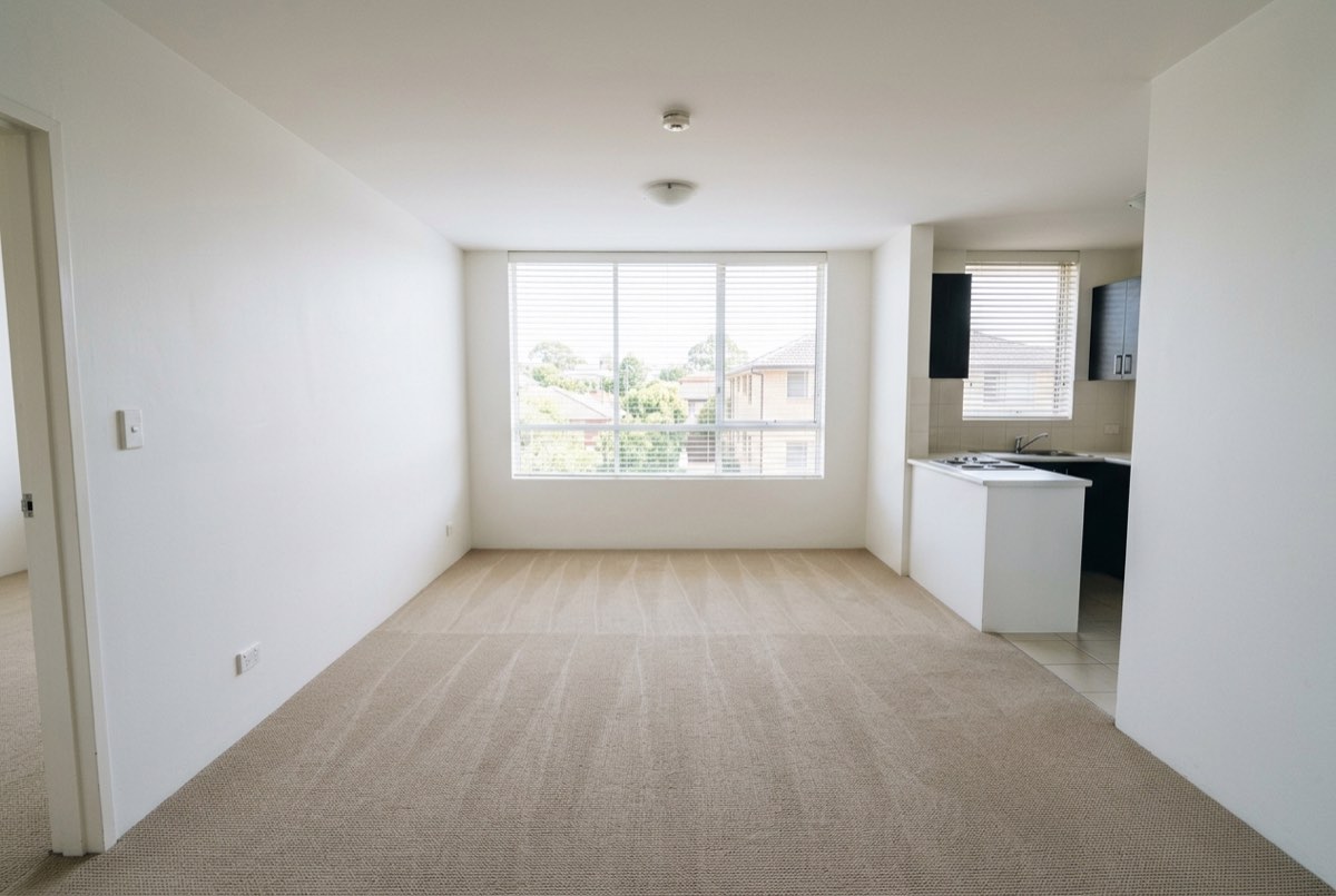An empty rental living area cleared of furniture and rubbish at the end of a lease